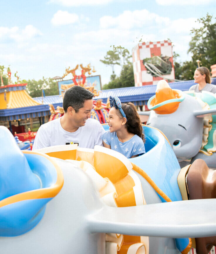 Father and daughter riding the Dumbo ride.