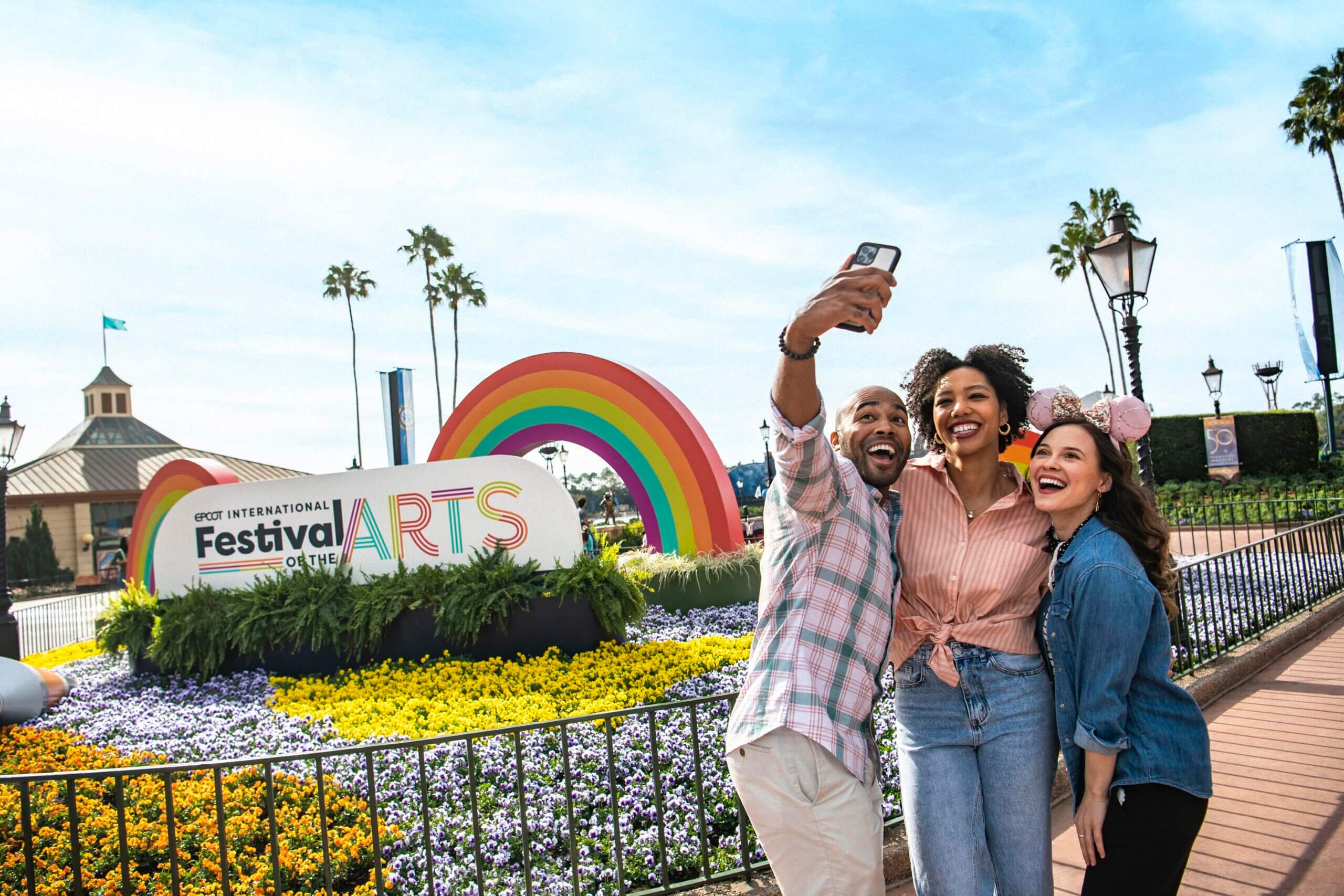 Family posing in front of the Festival of the Arts logo
