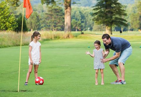 A Father and his Two Daughters Playing FootGolf