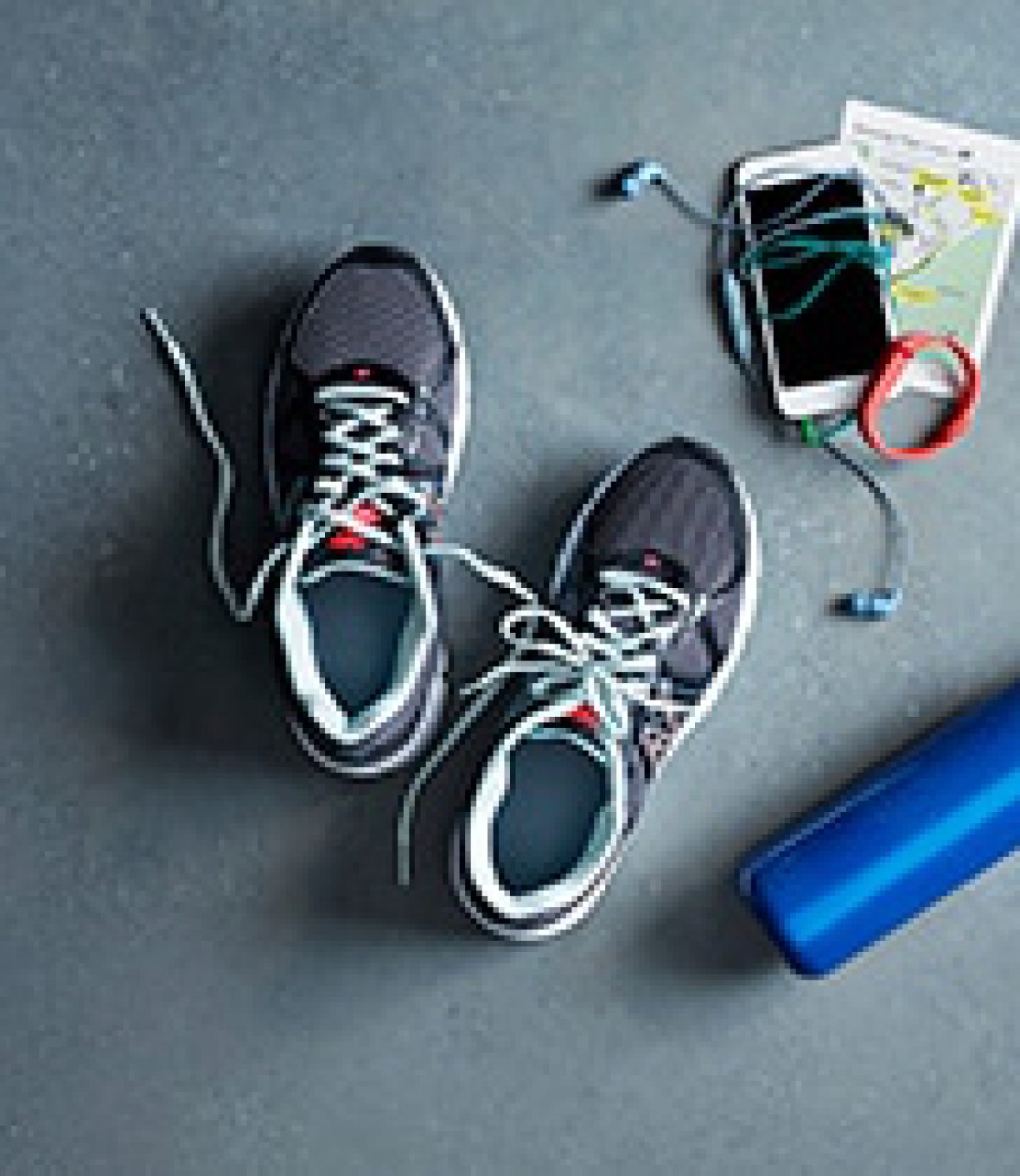 A pair of Training Shoes with a Water Bottle, a Phone and Headphones