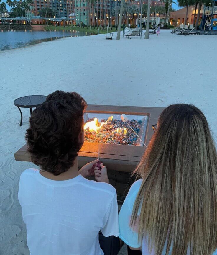 Boy and girl roasting marshmallows by the fire